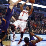 Chicago Bulls guard Derrick Rose (1) shoots between Phoenix Suns center Alex Len (21) and forward Markieff Morris (11) during the first half of an NBA basketball game in Chicago, on Saturday, Feb. 21, 2015. (AP Photo/Jeff Haynes)
