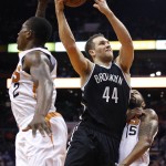 Brooklyn Nets' Bojan Bogdanovic (44), of Croatia, drives between Phoenix Suns' Eric Bledsoe (2) and Marcus Morris (15) to score during the first half of an NBA basketball game Wednesday, Nov. 12, 2014, in Phoenix. (AP Photo/Ross D. Franklin)