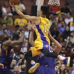 Los Angeles Lakers' Jeremy Lin, top, goes up for a basket over Phoenix Suns' Shavlik Randolph, bottom right, and Anthony Tolliver during the second half of a preseason NBA basketball game Tuesday, Oct. 21, 2014, in Anaheim, Calif. The Suns won 114-108 in overtime. (AP Photo/Jae C. Hong)