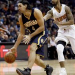 Indiana Pacers forward Luis Scola (4) moves the ball up court as Phoenix Suns forward Markieff Morris (11) defends during the first half of an NBA basketball game, Tuesday, Dec. 2, 2014, in Phoenix. (AP Photo/Matt York)