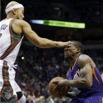 Milwaukee Bucks' Jerryd Bayless fouls Phoenix Suns' Eric Bledsoe as he drives to the basket during the second half of an NBA basketball game Tuesday, Jan. 6, 2015, in Milwaukee. (AP Photo/Morry Gash)