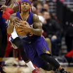 Washington Wizards guard John Wall (2) reaches for the ball as Phoenix Suns guard Isaiah Thomas (3) runs in the second half of an NBA basketball game, Sunday, Dec. 21, 2014, in Washington. Wall was called for a foul on the play. The Suns won 104-92. (AP Photo/Alex Brandon)