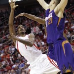 Houston Rockets' Trevor Ariza (1) is off balance as he shoots for two points over Phoenix Suns' Alex Len (21) in the second half of an NBA basketball game Saturday, Dec. 6, 2014, in Houston. The Rockets won 100-95. (AP Photo/Pat Sullivan)