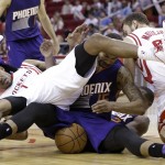 Phoenix Suns' Marcus Morris (15) and Houston Rockets Trevor Ariza (1) and Donatas Motiejunas get tangled up with the ball in the second half of an NBA basketball game Saturday, Dec. 6, 2014, in Houston. The Rockets won 100-95. (AP Photo/Pat Sullivan)