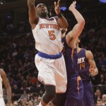 New York Knicks' Tim Hardaway Jr. (5) drives past Phoenix Suns' Miles Plumlee during the second half of an NBA basketball game, Saturday, Dec. 20, 2014, in New York. The Suns won the game 99-90. (AP Photo/Frank Franklin II)