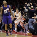 Los Angeles Clippers' Blake Griffin, center, celebrates his game-winning three-point basket as Phoenix Suns' P.J. Tucker, foreground, walks on the court following an NBA basketball game Monday, Dec. 8, 2014, in Los Angeles. The Clippers won 121-120 in overtime. (AP Photo/Jae C. Hong)