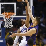 Oklahoma City Thunder guard Russell Westbrook, left, and Phoenix Suns center Alex Len, right, reach for the ball during a jump ball in the third quarter of an NBA basketball game in Oklahoma City, Sunday, Dec. 14, 2014. Oklahoma City won 112-88. (AP Photo/Sue Ogrocki)