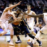 Indiana Pacers guard Rodney Stuckey, center, drives as Phoenix Suns center Miles Plumlee (22) and Eric Bledsoe (2) defend during the first half of an NBA basketball game in Phoenix Tuesday, Dec. 2, 2014 . (AP Photo/Matt York)