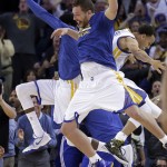 Golden State Warriors' David Lee, center, and Stephen Curry celebrate after a score, during a timeout in the second half of an NBA basketball game against the Phoenix Suns on Thursday, April 2, 2015, in Oakland, Calif. (AP Photo/Ben Margot)