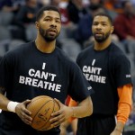 Phoenix Suns' Markieff Morris, left, and his brother, Marcus Morris, warm up prior to an NBA basketball game against the Milwaukee Bucks, Monday, Dec. 15, 2014, in Phoenix. Several athletes have worn "I Can't Breathe" shirts during warm ups in support of the family of Eric Garner, who died July 17 after a police officer placed him in a chokehold when he was being arrested for selling loose, untaxed cigarettes. (AP Photo/Matt York)