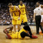 Cleveland Cavaliers' LeBron James grabs his head after a foul by the Phoenix Suns during the first half of an NBA basketball game, Tuesday, Jan. 13, 2015, in Phoenix. Looking at James are Matthew Dellavedova (8) and Tristan Thompson (13). (AP Photo/Matt York)
