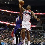 Phoenix Suns guard Isaiah Thomas (3) has his shot blocked by Washington Wizards center Kevin Seraphin (13), from France, in the first half of an NBA basketball game, Sunday, Dec. 21, 2014, in Washington. (AP Photo/Alex Brandon)
