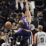 Phoenix Suns guard Eric Bledsoe, front, shoots against San Antonio Spurs forward Tiago Splitter, of Brazil, as Spurs' Tony Parker, right, of France, looks on, during the first half of an NBA basketball game on Friday, April 11, 2014, in San Antonio. (AP Photo/Darren Abate)
