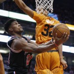 Chicago Bulls' Jimmy Butler (21) drives around Phoenix Suns' Brandan Wright (32) to score during the first half of an NBA basketball game Friday, Jan. 30, 2015, in Phoenix. (AP Photo/Ross D. Franklin)