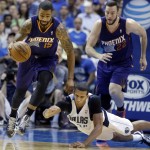 Phoenix Suns forward Marcus Morris (15) comes up with the ball against Dallas Mavericks forward Brandan Wright (34) as Suns' Miles Plumlee (22) runs up during the first half of an NBA basketball game on Saturday, April 12, 2014, in Dallas. (AP Photo/LM Otero)