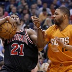 Chicago Bulls' Jimmy Butler (21) tries to gain control of the ball after Phoenix Suns' Marcus Morris, right, slapped at it during the first half of an NBA basketball game Friday, Jan. 30, 2015, in Phoenix. (AP Photo/Ross D. Franklin)