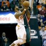 Phoenix Suns' Markieff Morris is fouled by Milwaukee Bucks' Larry Sanders, right, during the first half of an NBA basketball game, Monday, Dec. 15, 2014, in Phoenix. (AP Photo/Matt York)