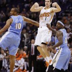 Phoenix Suns' Goran Dragic (1) gets off a pass between Denver Nuggets' Arron Afflalo (10) and Ty Lawson (3) during the second half of an NBA basketball game, Wednesday, Nov. 26, 2014, in Phoenix. The Suns defeated the Nuggets 120-112. (AP Photo/Ross D. Franklin)