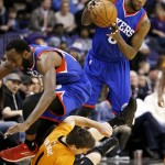 As Phoenix Suns' Goran Dragic (1), of Slovenia, collides with Philadelphia 76ers' Luc Mbah a Moute, left, 76ers' Tony Wroten, right, controls the ball during the first half of an NBA basketball game Friday, Jan. 2, 2015, in Phoenix. (AP Photo/Ross D. Franklin)
