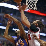 Chicago Bulls center Joakim Noah (13) and Phoenix Suns forward Marcus Morris (15) battle for the rebound during the first half of an NBA basketball game in Chicago, on Saturday, Feb. 21, 2015. (AP Photo/Jeff Haynes)