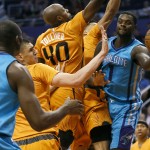 Charlotte Hornets guard Lance Stephenson (1) dishes to teammate Bismack Biyombo (8) around Phoenix Suns forward Anthony Tolliver (40) and Gerald Green during the first half of an NBA basketball game, Friday, Nov. 14, 2014, in Phoenix. (AP Photo/Matt York)
