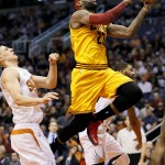 Cleveland Cavaliers' LeBron James (23) drives against Phoenix Suns' Alex Len during the first half of an NBA basketball game, Tuesday, Jan. 13, 2015, in Phoenix. (AP Photo/Matt York)