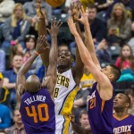 Indiana Pacer's Ian Mahinmi (28) clears the ball out from under the basket with Phoenix Sun's Anthony Tolliver (40) and Alex Len (21) pressuring him during the first half of an NBA basketball game, Saturday, Nov. 22, 2014, in Indianapolis. (AP Photo/Doug McSchooler)