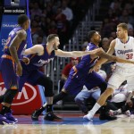 Los Angeles Clippers' Blake Griffin, right, controls the ball as, from left, Phoenix Suns' Eric Bledsoe, Miles Plumlee, and Markieff Morris defend him during the first half of an NBA basketball game Saturday, Nov. 15, 2014, in Los Angeles. (AP Photo/Danny Moloshok)