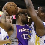 Phoenix Sun's P.J. Tucker, center, looks to pass away from Golden State Warriors' Harrison Barnes, right, and Andrew Bogut during the first half of an NBA basketball game, Wednesday, Feb. 20, 2013, in Oakland, Calif. (AP Photo/Ben Margot)