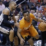 Phoenix Suns' Ish Smith, right, drives past San Antonio Spurs' Patty Mills, of Australia, during the first half of an NBA basketball game, Friday, Feb. 21, 2014, in Phoenix. (AP Photo/Ross D. Franklin)