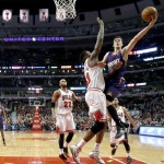 Phoenix Suns guard Goran Dragic (1) shoots over Chicago Bulls center Nazr Mohammed as Taj Gibson (22) watches during the second half of an NBA basketball game, Tuesday, Jan. 7, 2014, in Chicago. The Bulls won 92-87. (AP Photo/Charles Rex Arbogast)