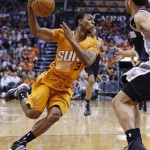 Phoenix Suns' Ish Smith (3) drives past San Antonio Spurs' Cory Joseph, right, during the first half of an NBA basketball game, Friday, Feb. 21, 2014, in Phoenix. (AP Photo/Ross D. Franklin)