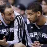 San Antonio Spurs' Manu Ginobili, left, and Tim Duncan talk as they spend most of the second half of an NBA basketball game against the Phoenix Suns on the bench, Friday, Feb. 21, 2014, in Phoenix. The Suns defeated the Spurs 106-85. (AP Photo/Ross D. Franklin)