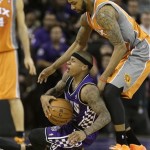 Sacramento Kings guard Isaiah Thomas, left, goes to the floor with the ball against Phoenix Suns forward Marcus Morris in the fourth quarter of an NBA basketball game in Sacramento, Calif., Friday, March 8, 2013. The Kings won 121-112. (AP Photo/Rich Pedroncelli)