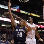 New Orleans Pelicans shooting guard Eric Gordon (10), left, scores on Phoenix Suns point guard Eric Bledsoe (2) in the first quarter during an NBA basketball game on Sunday, Nov. 10, 2013, in Phoenix. (AP Photo/Rick Scuteri)