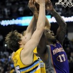 Denver Nuggets center Timofey Mozgov, left, of Russia, fouls Phoenix Suns guard P.J. Tucker, right, in the second quarter of an NBA basketball game on Wednesday, April 17, 2013, in Denver. (AP Photo/Chris Schneider)