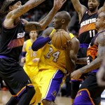 Los Angeles Lakers' Kobe Bryant (24) is pressured by Phoenix Suns' Michael Beasley, left, Shannon Brown (6), and Markieff Morris (11) during the first half on an NBA basketball game, Wednesday, Jan. 30, 2013, in Phoenix. (AP Photo/Matt York)