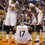 Phoenix Suns' P.J. Tucker (17) sits on the court after being injured as teammates Archie Goodwin (20) and Markieff Morris help him up against the Milwaukee Bucks' during the first half of an NBA basketball game, Saturday, Jan. 4, 2014, in Phoenix. Tucker left the game. (AP Photo/Matt York)
