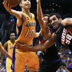 Los Angeles Lakers' Steve Nash (10) drives past Phoenix Suns' Hamed Haddadi (98), of Iran, and Goran Dragic, of Slovenia, in the first half of an NBA basketball game on Monday, March 18, 2013, in Phoenix. (AP Photo/Ross D. Franklin)