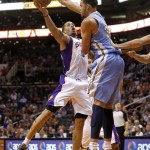 Phoenix Suns' Michael Beasley shoots under Denver Nuggets' JaVale McGee, right, during the second half of an NBA basketball game, Monday, March 11, 2013, in Phoenix. (AP Photo/Matt York)