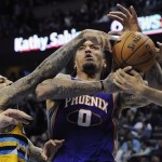 
Denver Nuggets guard Wilson Chandler, left, tangles with Phoenix Suns forward Michael Beasley, center, in the second half of an NBA basketball game on Wednesday, April 17, 2013, in Denver. The Nuggets won 118-98. (AP Photo/Chris Schneider)