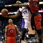 Phoenix Suns' Marcus Morris (15) is fouled by Toronto Raptors' Amir Johnson, right, during the second half of an NBA basketball game, Wednesday, March 6, 2013, in Phoenix. (AP Photo/Matt York)