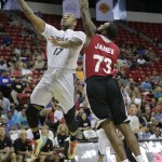 Phoenix Suns' P.J. Tucker (17) drives in for a shot against Miami Heat center Damion James in the first quarter of an NBA Summer League basketball game on Sunday, July 21, 2013, in Las Vegas. (AP Photo/Julie Jacobson)