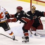 Phoenix Coyotes' Thomas Greiss, right, of Germany, makes a save on a shot as Coyotes' David Schlemko (6) and Calgary Flames' Lee Stempniak (22) battle in front of the net during the second period of an NHL hockey game Tuesday, Jan. 7, 2014, in Glendale, Ariz. Phoenix defeated Calgary 6-0. (AP Photo/Ross D. Franklin)