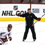 Phoenix Coyotes head coach Dave Tippett, right, shouts instructions as Paul Bissonnette (12) skates past during a Coyotes NHL hockey practice Tuesday, Jan. 15, 2013, in Glendale, Ariz. The NHL will start its 119 day lockout-shortened season Jan. 19.(AP Photo/Ross D. Franklin)