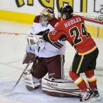 Phoenix Coyotes goalie Mike Smith, left, makes a save as Calgary Flames' Jiri Hudler, from Czech Republic, looks for the puck during first period of an NHL hockey game in Calgary, Alberta, Friday, April 12, 2013. (AP Photo/The Canadian Press, Larry MacDougal)