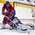 Montreal Canadiens defenseman Andrei Markov stops the puck in front of goalie Carey Price during the first period of an NHL hockey game against the Phoenix Coyotes on Tuesday, Dec. 17, 2013, in Montreal. (AP Photo/The Canadian Press, Paul Chiasson)