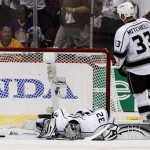 Los Angeles Kings goalie Jonathan Quick (32) lays on the ice after giving up a goal to Phoenix Coyotes' Marc-Antoine Pouliot while Kings' Willie Mitchell (33) skates past in the second period during Game 5 of the NHL hockey Stanley Cup Western Conference finals, Tuesday, May 22, 2012, in Glendale, Ariz. (AP Photo/Ross D. Franklin)