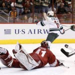 Minnesota Wild's Justin Fontaine (14) scores against Phoenix Coyotes' Mike Smith, left, as Wild's Matt Cooke (24) looks on during the first period in an NHL hockey game, Thursday, Jan. 9, 2014, in Glendale, Ariz. (AP Photo/Ross D. Franklin)