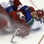 Phoenix Coyotes' Antoine Vermette (50) gets taken down by Vancouver Canucks' Keith Ballard during the second period in an NHL hockey game, Thursday, March 21, 2013, in Glendale, Ariz. (AP Photo/Ross D. Franklin)